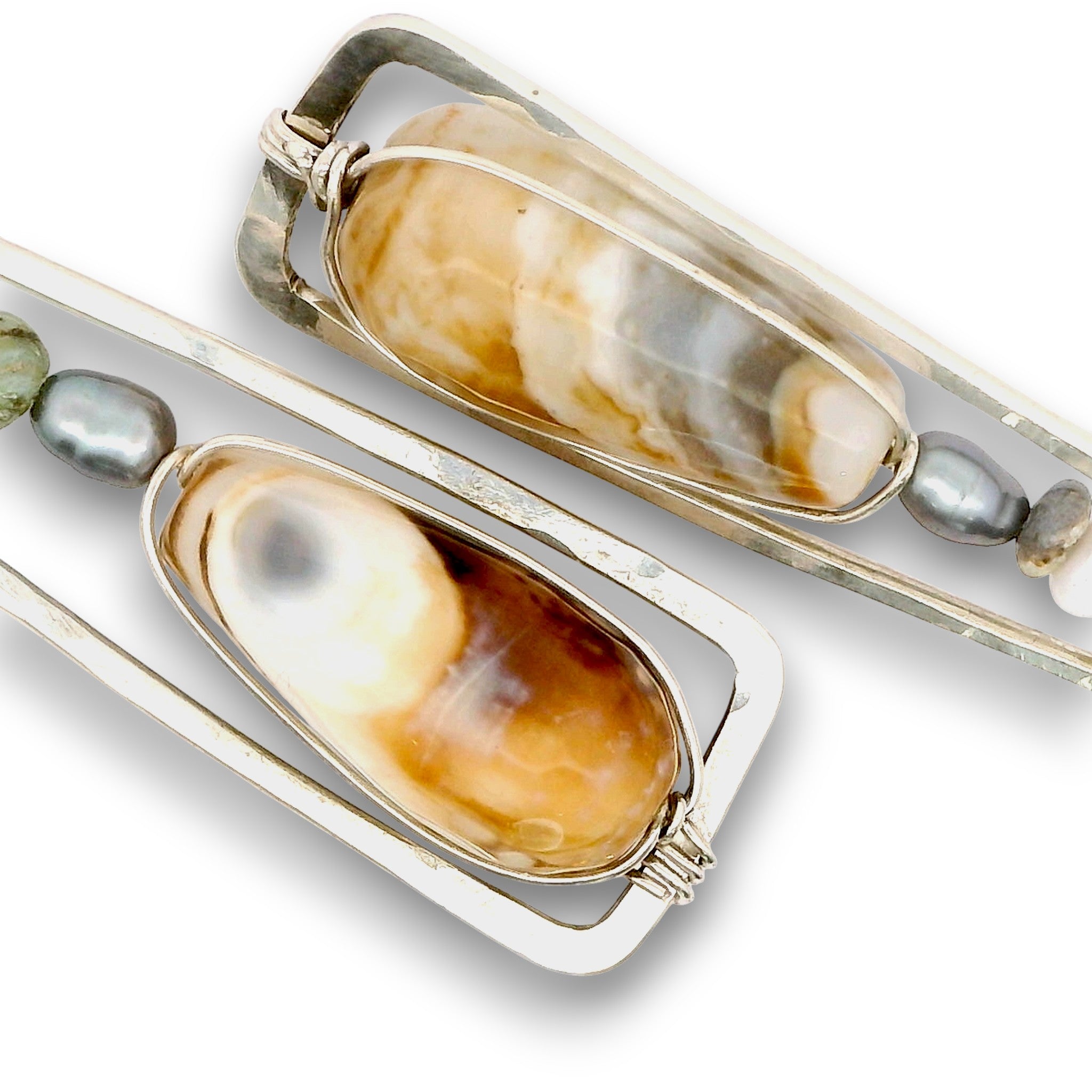 Two silver-toned rectangular pendant necklaces with large teardrop-shaped natural shell inlays in cream, tan, and brown, accented with small dark gray pearls, shown on a white background.