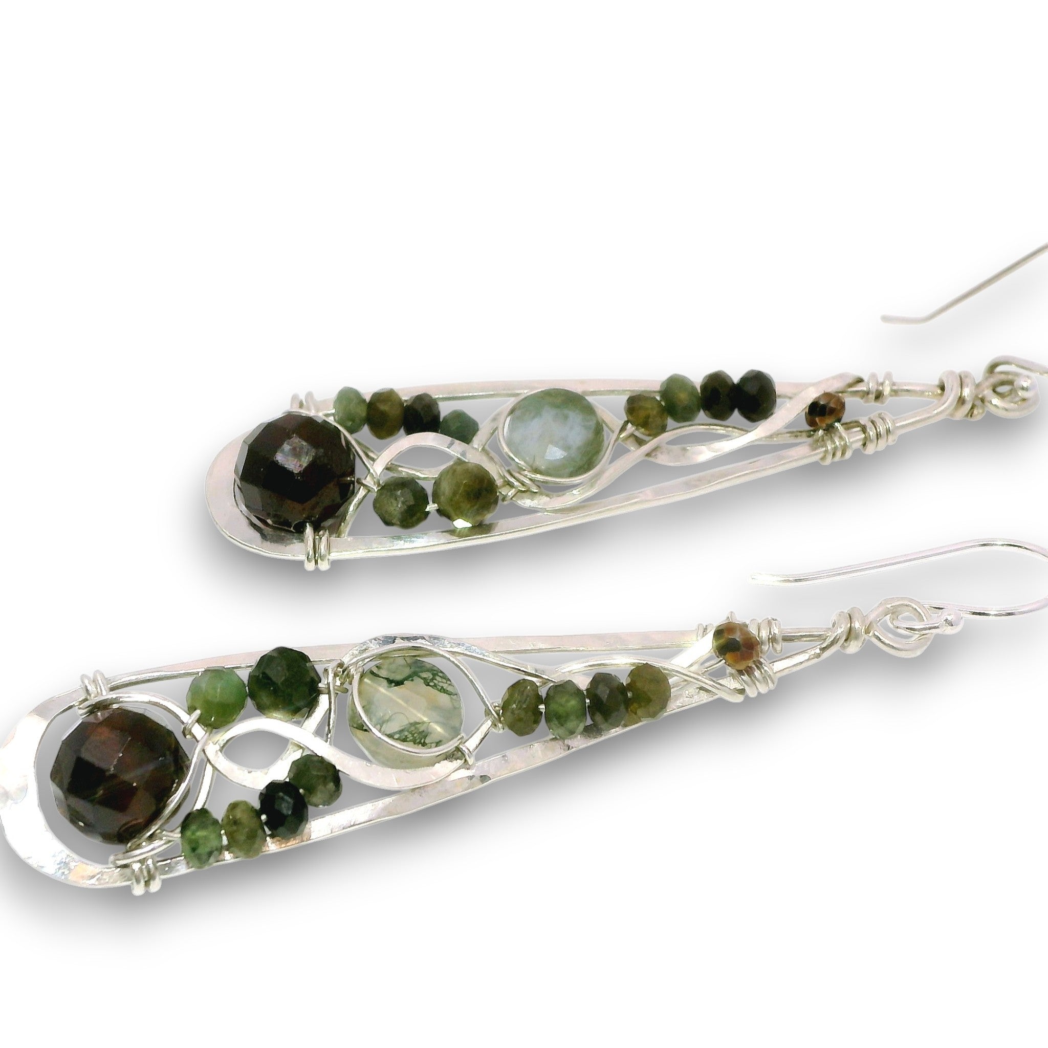 A pair of silver teardrop-shaped dangle earrings featuring green and brown gemstone beads and small round green beads, shown on a plain white background.