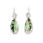 A pair of teardrop-shaped dangle earrings featuring light green aventurine gemstone centers, surrounded by silver and gold wire-wrapped settings with small dark green faceted gemstones, shown on a plain white background.