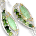 A pair of handmade dangle earrings featuring polished light green aventurine gemstone centers, accented with faceted green beads and small gold wire wraps, suspended from hammered silver-toned metal frames.