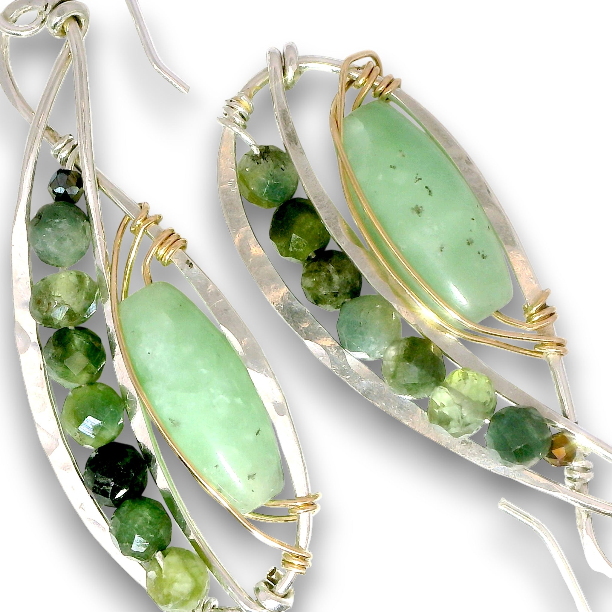 A pair of handmade dangle earrings featuring polished light green aventurine gemstone centers, accented with faceted green beads and small gold wire wraps, suspended from hammered silver-toned metal frames.