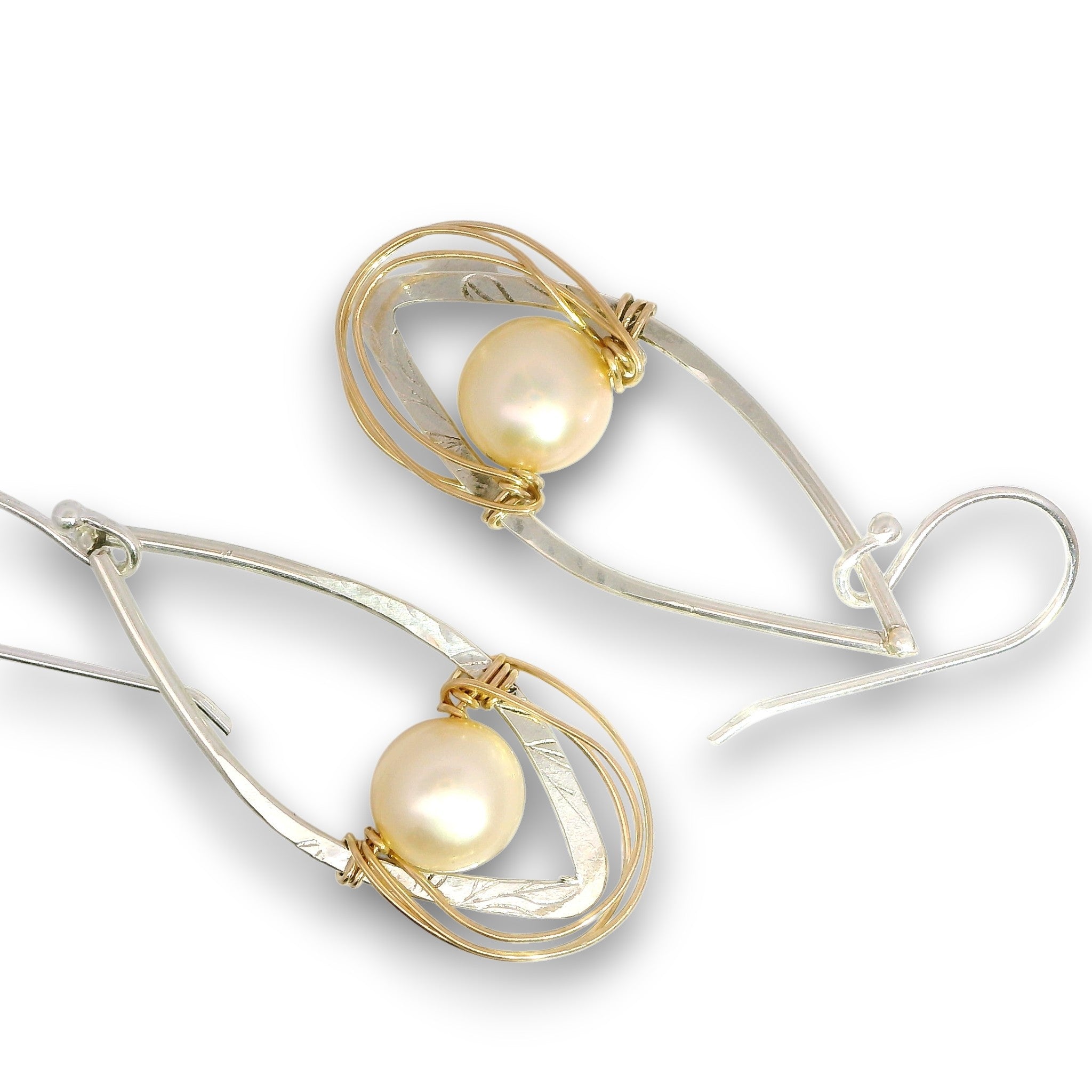 A pair of teardrop-shaped dangle earrings featuring a lustrous white pearl wrapped in textured gold and polished silver-tone metal loops, shown on a clean white background.