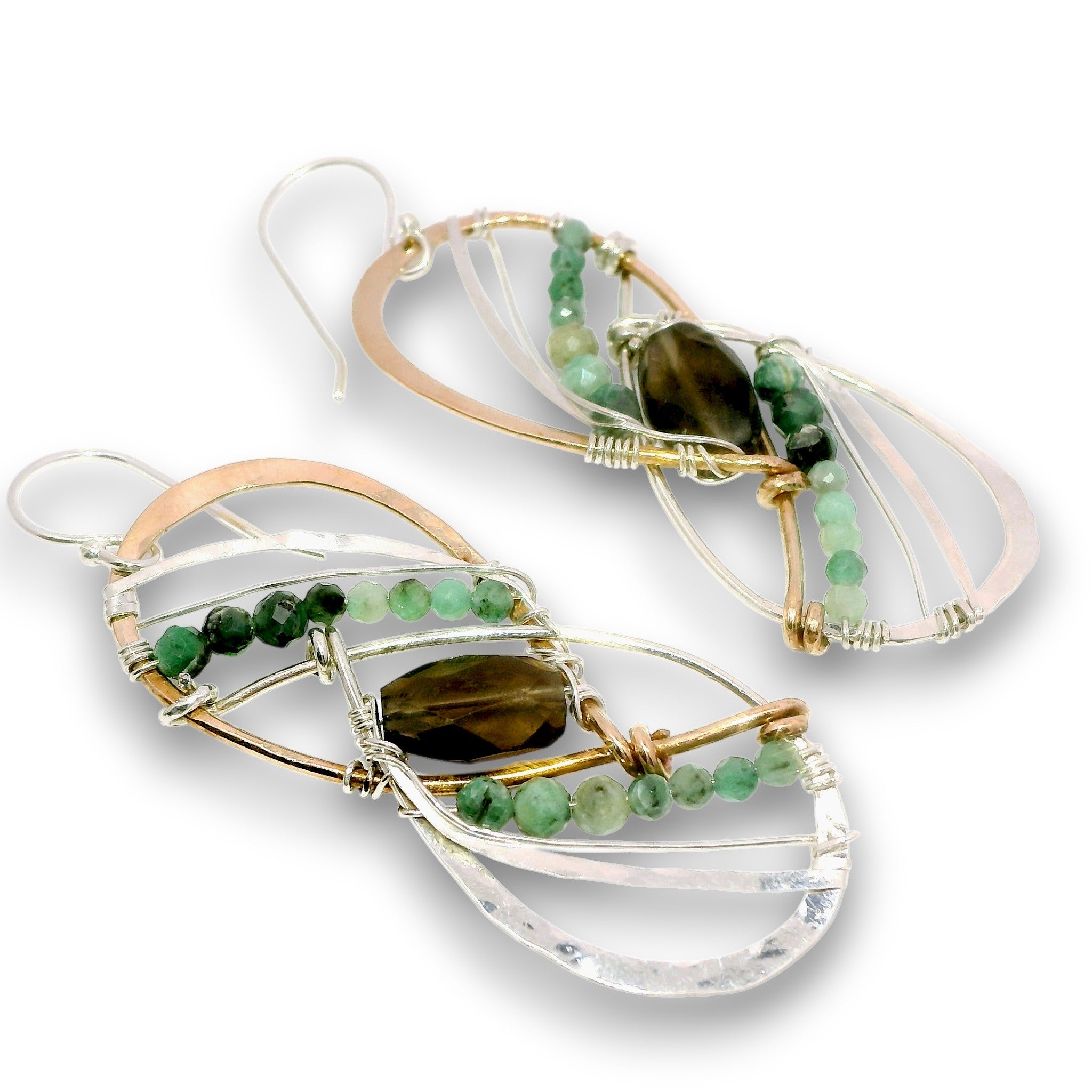 A pair of handmade dangle earrings featuring clear quartz crystal loops, green beads, a dark brown teardrop gemstone, and rose gold and silver wire wrapping on a white background.