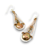 A pair of teardrop-shaped dangle earrings featuring iridescent baroque pearls wrapped in copper wire, suspended from clear resin teardrop pendants with silver fishhook ear wires, shown on a white background.