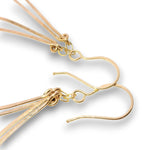 Gold-toned metal earrings with multiple thin flat strands hanging from simple hook shapes, shown on a clean white background.