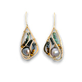 A pair of gold teardrop dangle earrings featuring a large iridescent pearl, green beads, and tiger's eye beads, set against a plain white background.