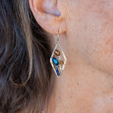 A pair of sterling silver mini diamond earrings featuring rust colored fresh water pearls, golden crystals, blue crystal drops, and lapis gemstones
