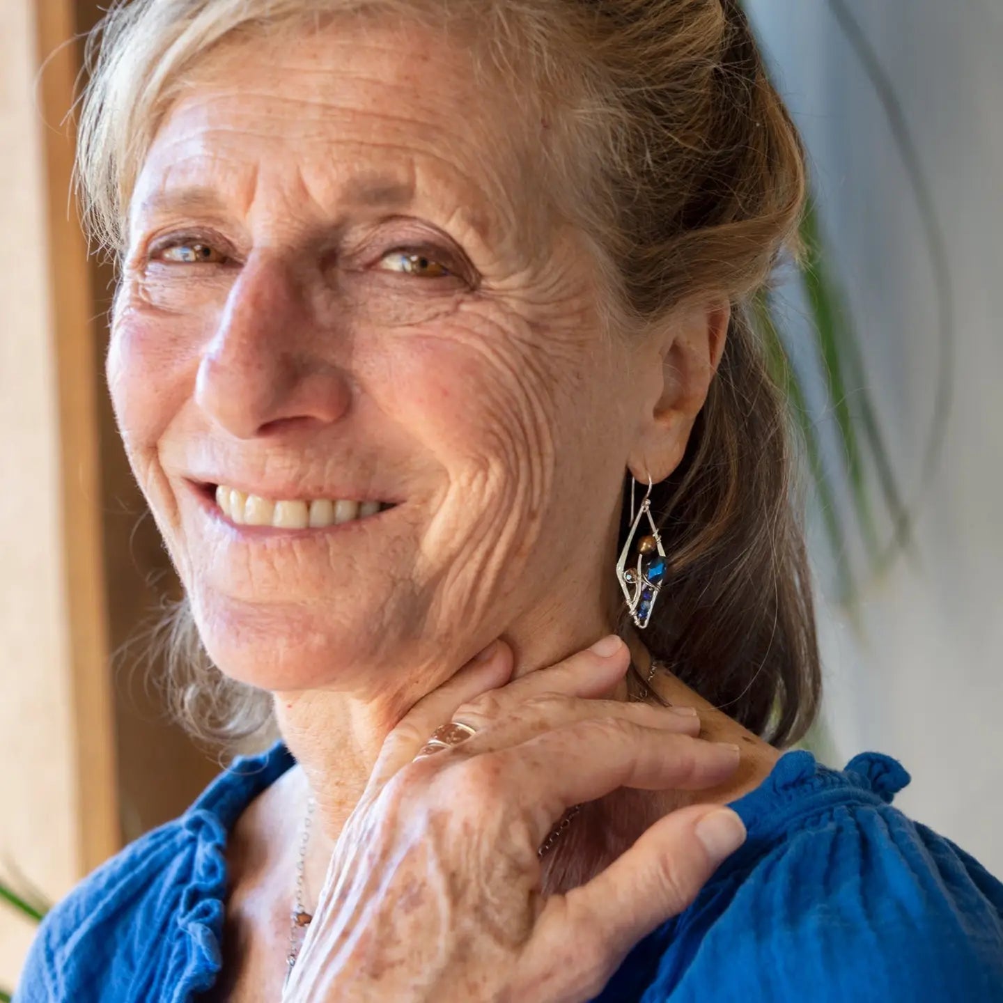 A pair of sterling silver mini diamond earrings featuring rust colored fresh water pearls, golden crystals, blue crystal drops, and lapis gemstones