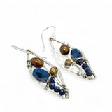A pair of sterling silver mini diamond earrings featuring rust colored fresh water pearls, golden crystals, blue crystal drops, and lapis gemstones
