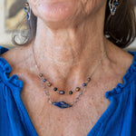 A diamond lapis gemstone is bezel set into sterling silver with handmade hammered link chain with rust and purple colored fresh water pearls necklace