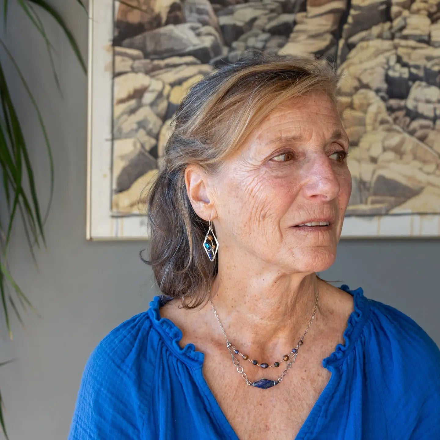 A diamond lapis gemstone is bezel set into sterling silver with handmade hammered link chain with rust and purple colored fresh water pearls necklace