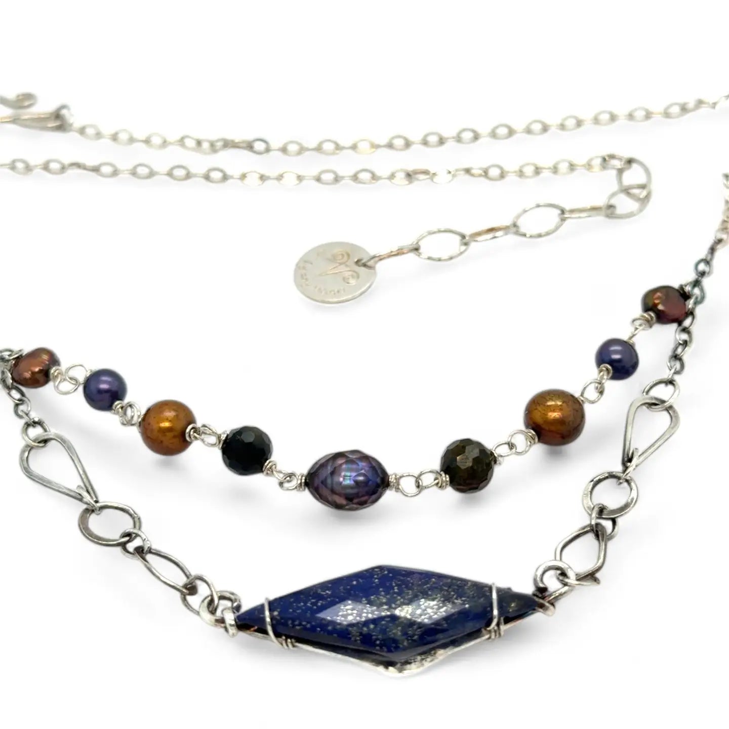 A diamond lapis gemstone is bezel set into sterling silver with handmade hammered link chain with rust and purple colored fresh water pearls necklace
