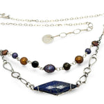 A diamond lapis gemstone is bezel set into sterling silver with handmade hammered link chain with rust and purple colored fresh water pearls necklace