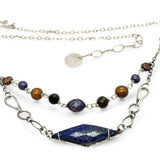 A diamond lapis gemstone is bezel set into sterling silver with handmade hammered link chain with rust and purple colored fresh water pearls necklace