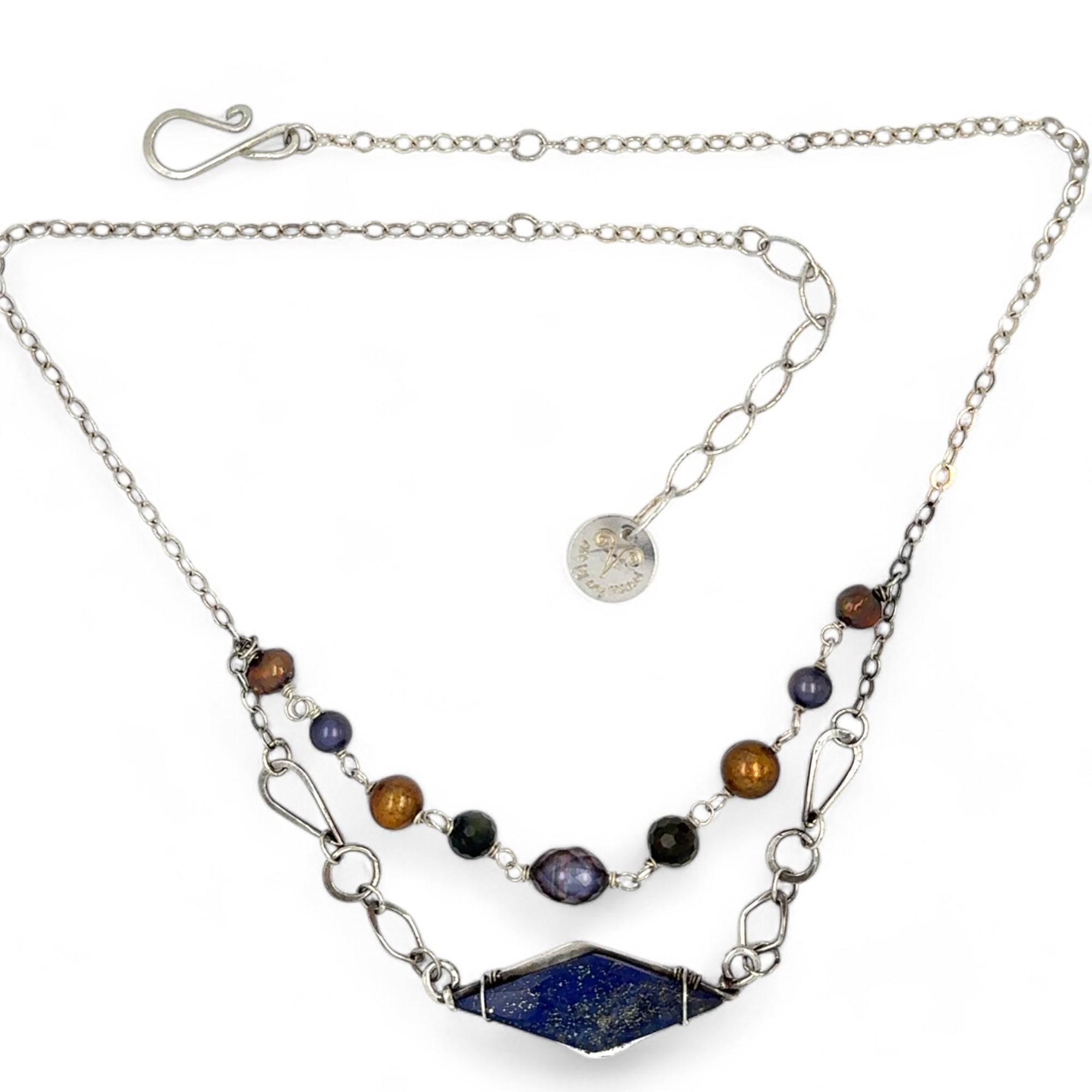 A diamond lapis gemstone is bezel set into sterling silver with handmade hammered link chain with rust and purple colored fresh water pearls necklace