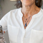 A sterling silver necklace with a handmade prong pendant featuring a deep blue sodalite natural gemstone, micro faceted sodalite and labradorite gemstones, and a lustrous gray blue fresh water pearl, connected to an oxidized link chain.