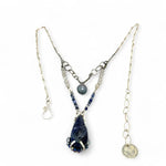 A sterling silver necklace with a handmade prong pendant featuring a deep blue sodalite natural gemstone, micro faceted sodalite and labradorite gemstones, and a lustrous gray blue fresh water pearl, connected to an oxidized link chain.