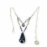 A sterling silver necklace with a handmade prong pendant featuring a deep blue sodalite natural gemstone, micro faceted sodalite and labradorite gemstones, and a lustrous gray blue fresh water pearl, connected to an oxidized link chain.