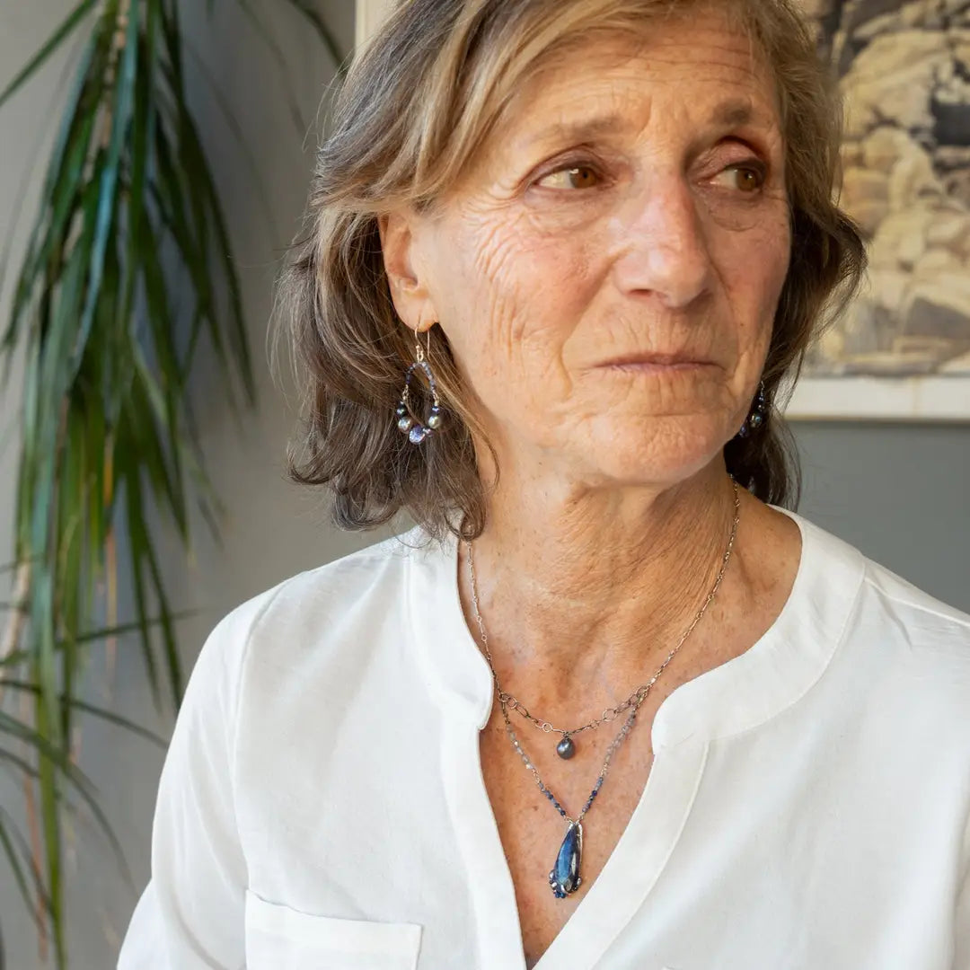 A sterling silver necklace with a handmade prong pendant featuring a deep blue sodalite natural gemstone, micro faceted sodalite and labradorite gemstones, and a lustrous gray blue fresh water pearl, connected to an oxidized link chain.