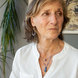 A sterling silver necklace with a handmade prong pendant featuring a deep blue sodalite natural gemstone, micro faceted sodalite and labradorite gemstones, and a lustrous gray blue fresh water pearl, connected to an oxidized link chain.