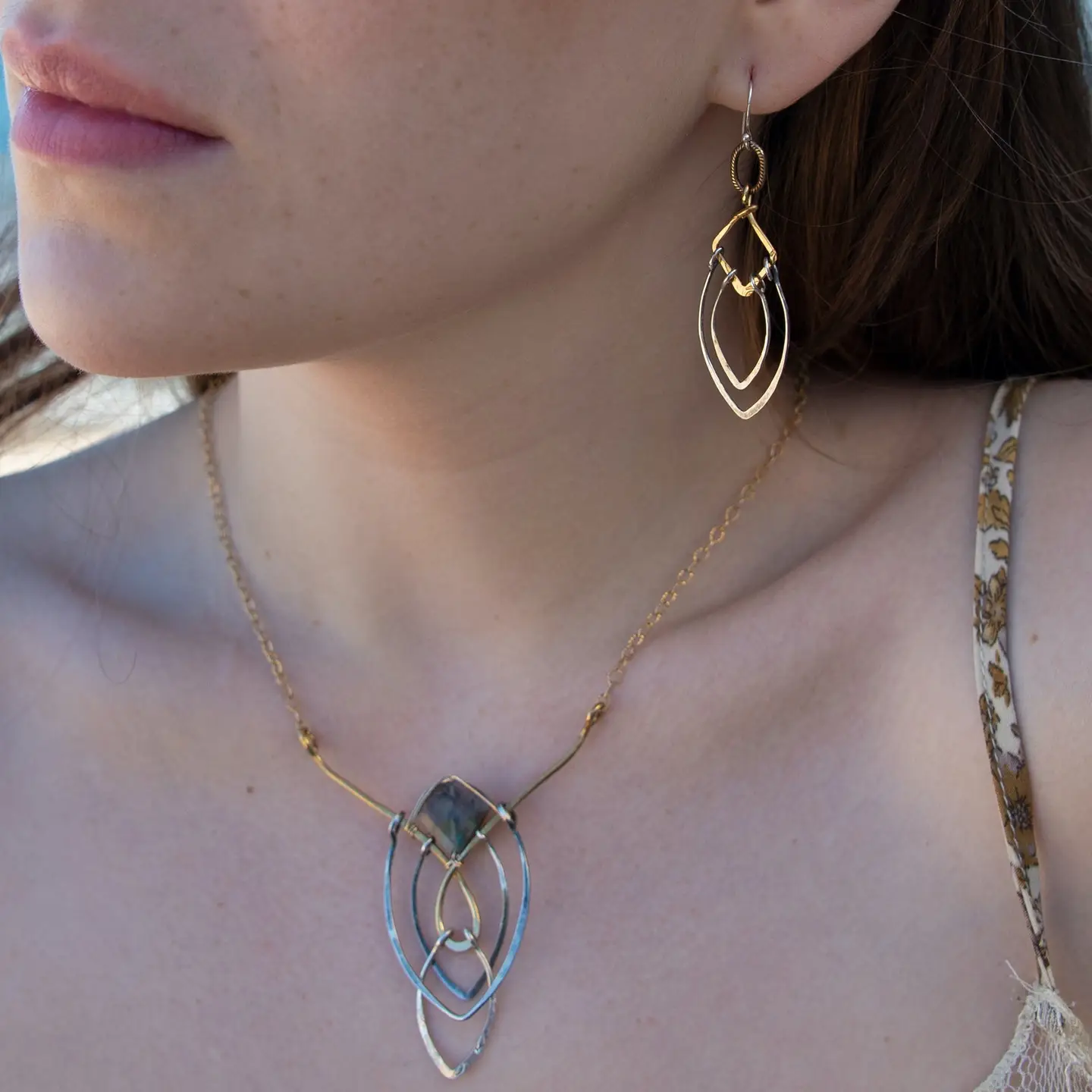Sterling silver double teardrops swinging from stamped brass diamonds, all hanging from a braided brass link