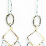 Sterling silver double teardrops swinging from stamped brass diamonds, all hanging from a braided brass link