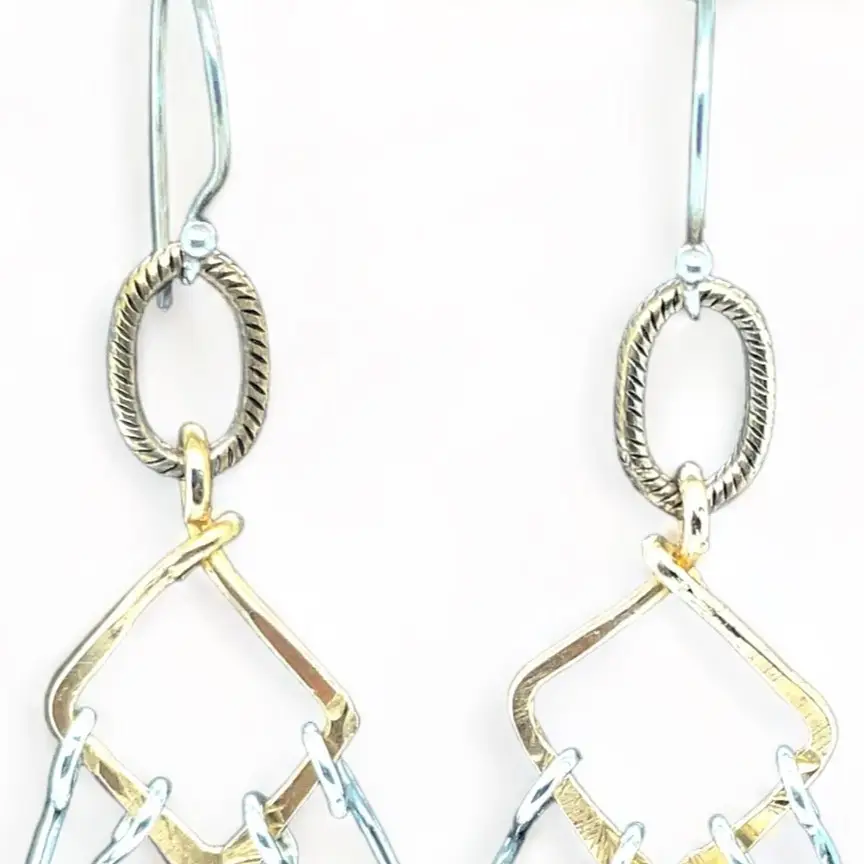 Sterling silver double teardrops swinging from stamped brass diamonds, all hanging from a braided brass link