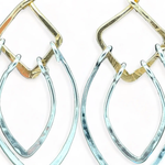 Sterling silver double teardrops swinging from stamped brass diamonds, all hanging from a braided brass link