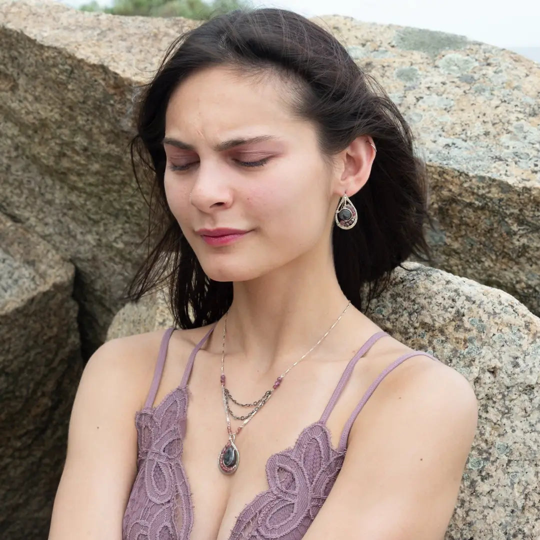 Floral stamped sterling silver drop earrings with larvikite smooth coins surrounded by pink tourmaline, lepidolite, and pyrite gemstones, with a built in earring hook that wears like a post earring
