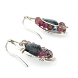 Floral stamped sterling silver drop earrings with larvikite smooth coins surrounded by pink tourmaline, lepidolite, and pyrite gemstones, with a built in earring hook that wears like a post earring