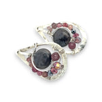 Floral stamped sterling silver drop earrings with larvikite smooth coins surrounded by pink tourmaline, lepidolite, and pyrite gemstones, with a built in earring hook that wears like a post earring