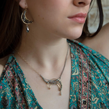 A necklace with a silver and brass moon eclipse design, featuring faceted labradorite gemstones and a single white sapphire drop, oxidized sterling silver and brass twist wires, gold filled texture chain on one side and double sterling silver chain on the other side