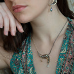 A necklace with a silver and brass moon eclipse design, featuring faceted labradorite gemstones and a single white sapphire drop, oxidized sterling silver and brass twist wires, gold filled texture chain on one side and double sterling silver chain on the other side