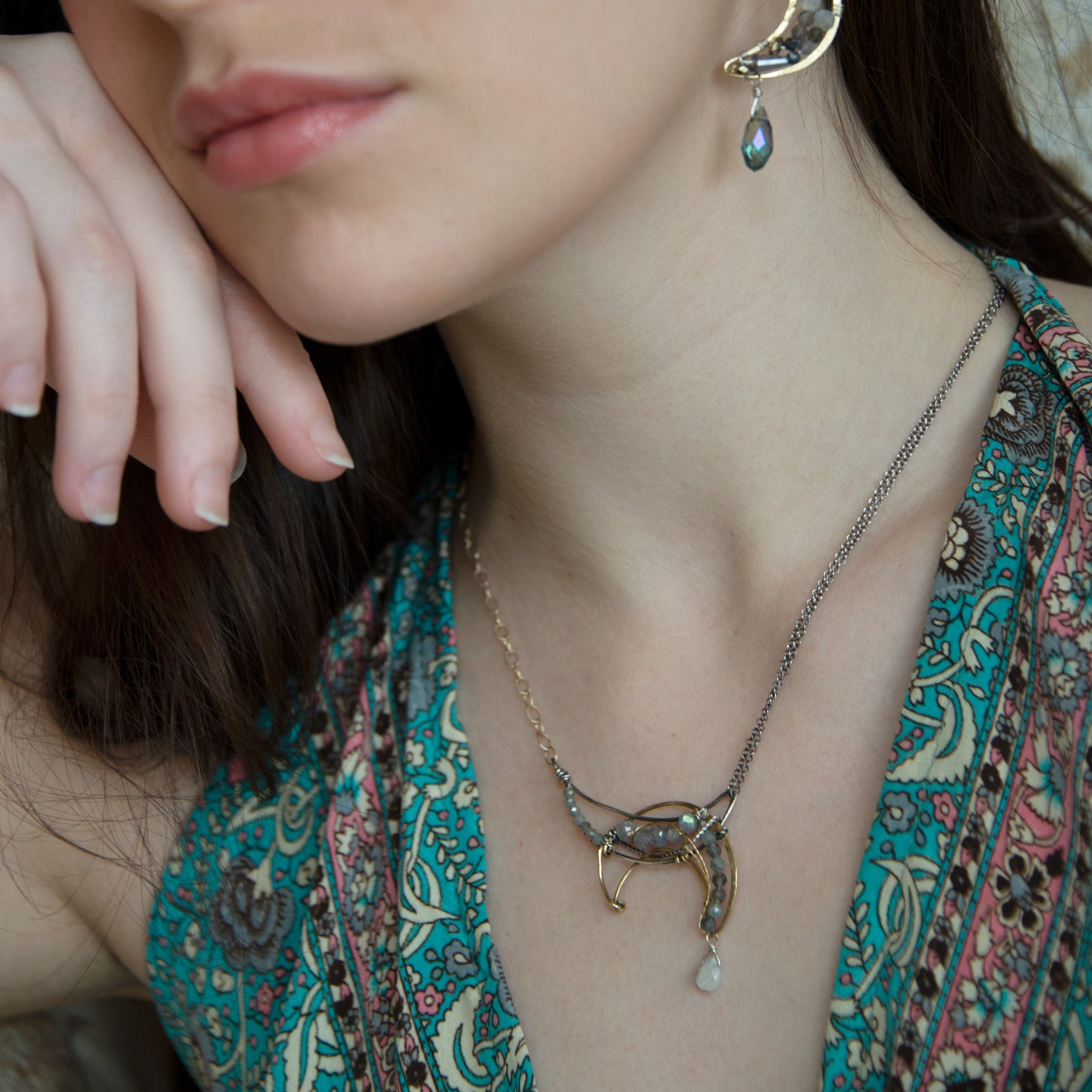 A necklace with a silver and brass moon eclipse design, featuring faceted labradorite gemstones and a single white sapphire drop, oxidized sterling silver and brass twist wires, gold filled texture chain on one side and double sterling silver chain on the other side