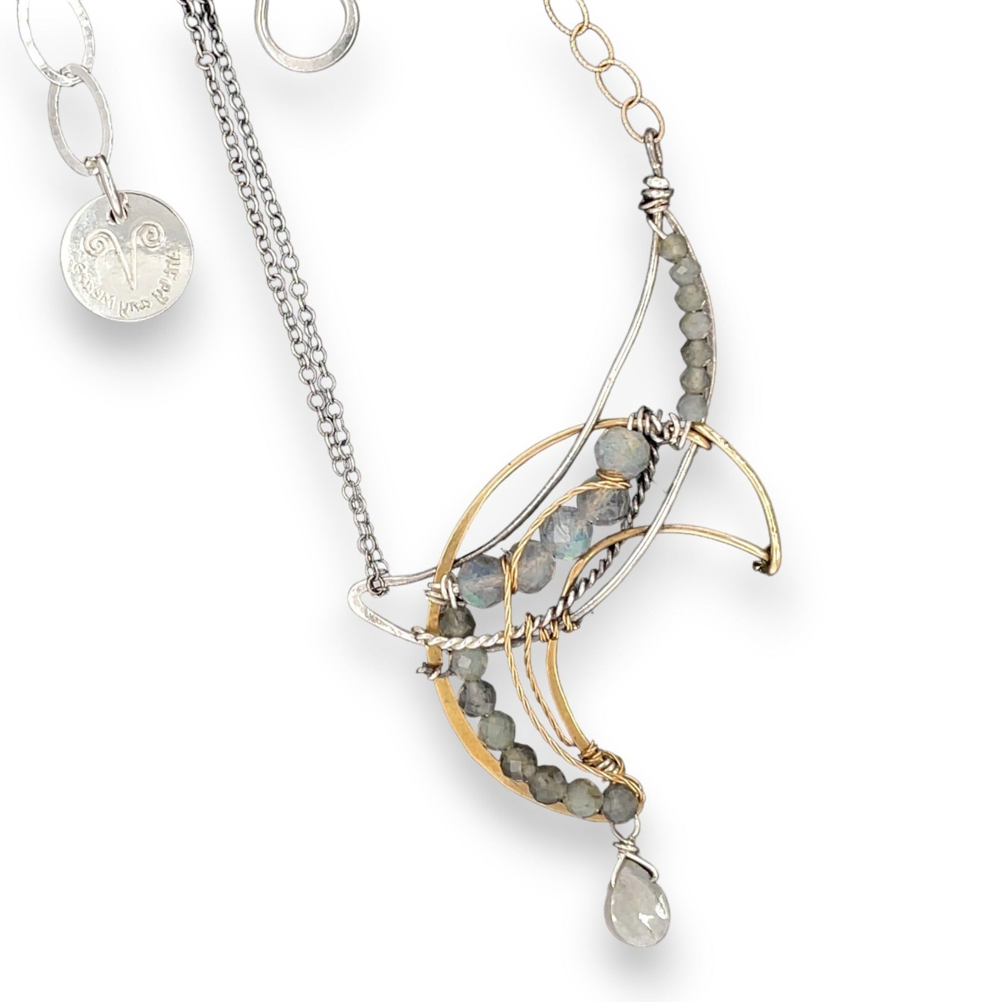 A necklace with a silver and brass moon eclipse design, featuring faceted labradorite gemstones and a single white sapphire drop, oxidized sterling silver and brass twist wires, gold filled texture chain on one side and double sterling silver chain on the other side