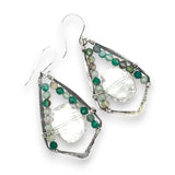 A pair of handmade oxidized sterling silver pointy drop earrings with green onyx faceted gemstones and a clear quartz crystal in the center, attached to sterling silver French hooks.