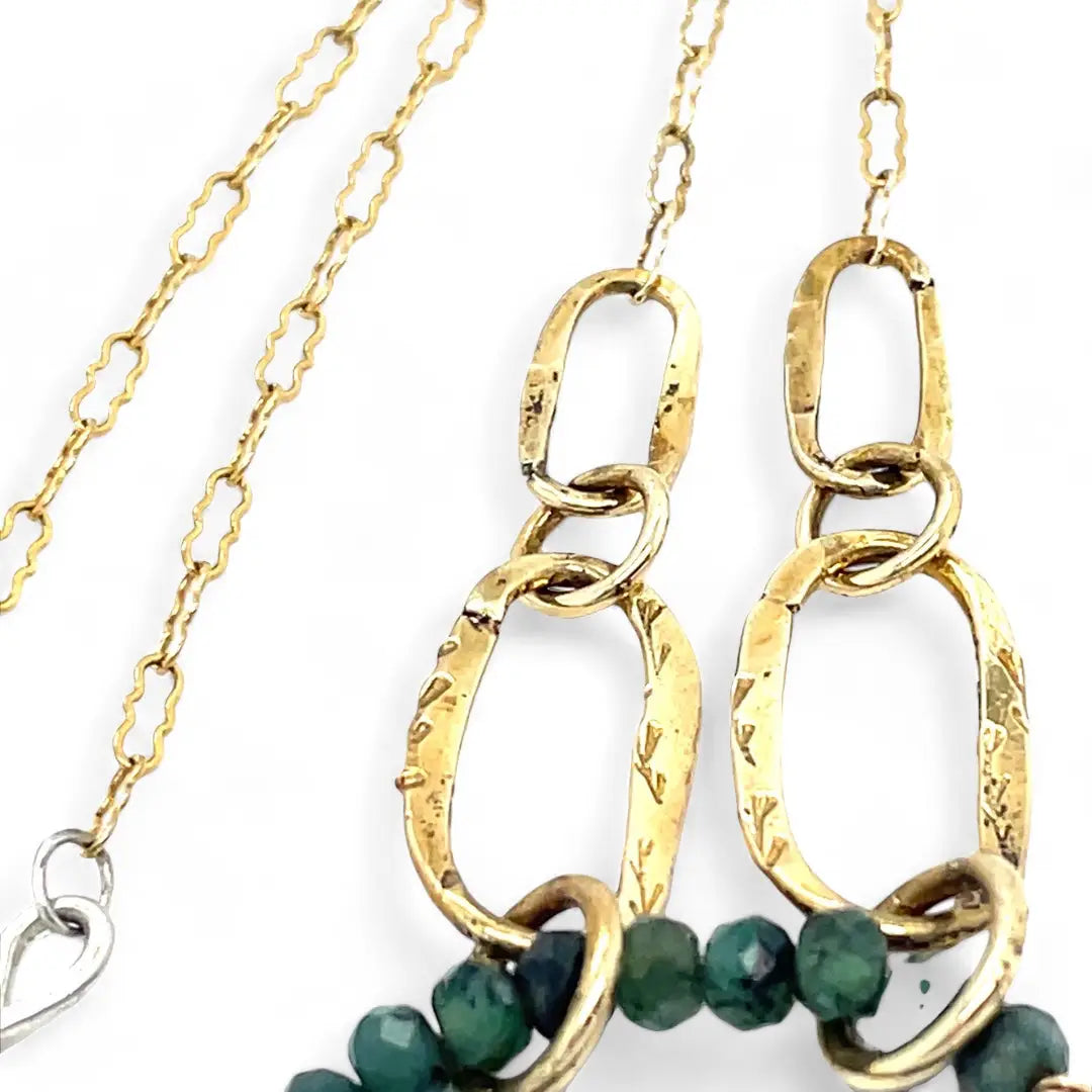 A gold-filled crinkle chain holding handmade brass links and an emerald ring  necklace
