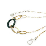 A gold-filled crinkle chain holding handmade brass links and an emerald ring  necklace