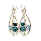 Green pearl, faceted bloodstone gemstone, and blue green crystal are nestled within brass infinity earrings on gold filled wire