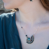 A  hand formed bronze pendant necklace with green fresh water pearl coin, bloodstone faceted gems, crystal, and pyrite on a sterling silver delicate chain with sparkly rose quartz links