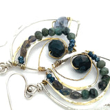 Crystal, emerald, and opal gemstones vein between layers of brass wire inside a sterling silver leaf shaped earring
