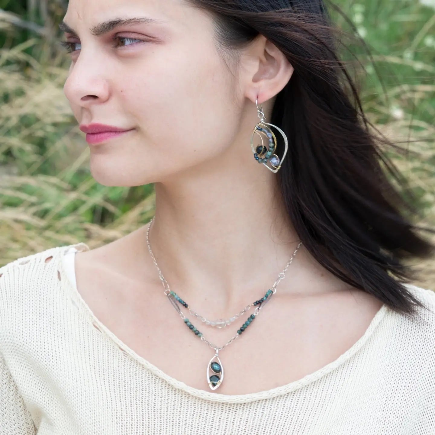 Crystal, emerald, and opal gemstones vein between layers of brass wire inside a sterling silver leaf shaped earring