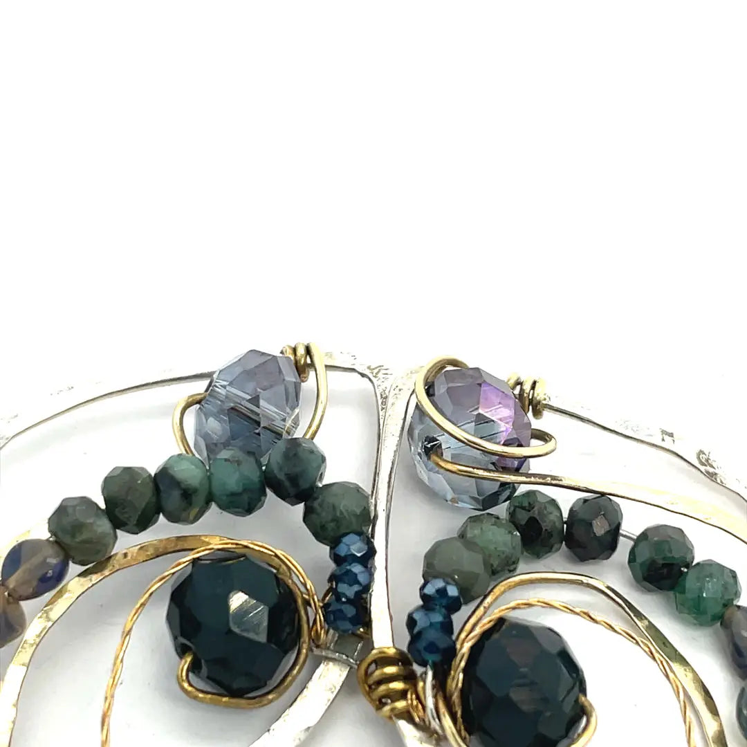Crystal, emerald, and opal gemstones vein between layers of brass wire inside a sterling silver leaf shaped earring