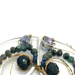 Crystal, emerald, and opal gemstones vein between layers of brass wire inside a sterling silver leaf shaped earring