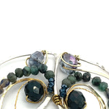 Crystal, emerald, and opal gemstones vein between layers of brass wire inside a sterling silver leaf shaped earring