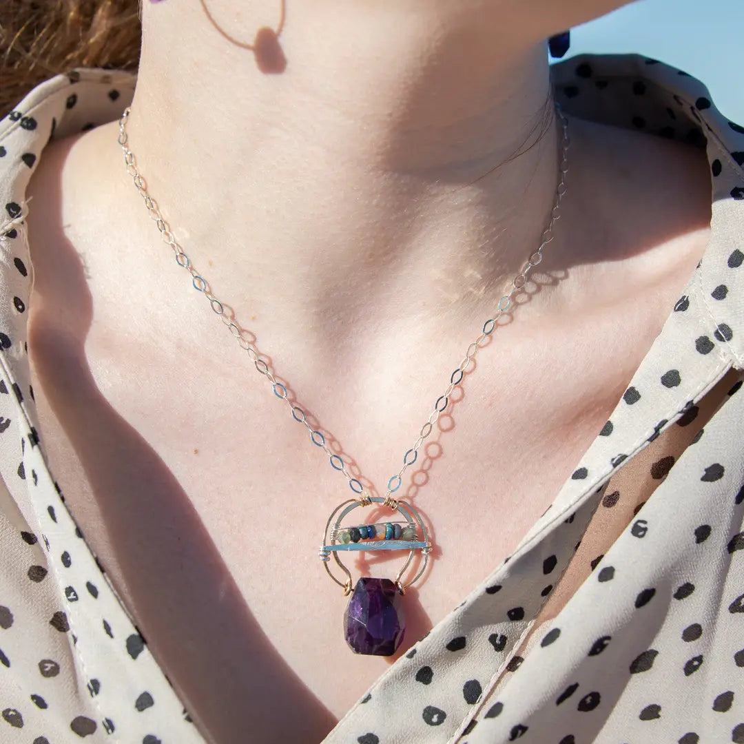 Handmade hammered bronze pendant with built in amethyst nugget, accented with opal and green amethyst on sterling silver wire, featuring a sterling silver chain