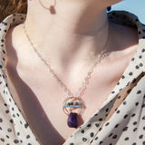 Handmade hammered bronze pendant with built in amethyst nugget, accented with opal and green amethyst on sterling silver wire, featuring a sterling silver chain