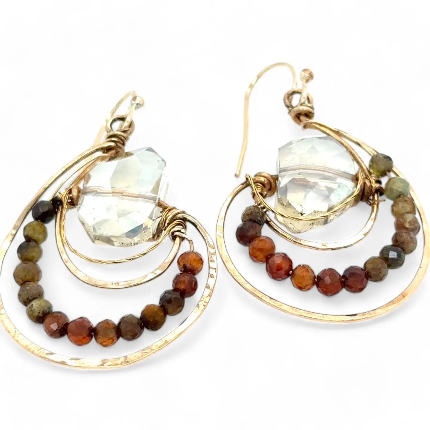 A pair of bronze hoop earrings with ombre micro faceted hessonite gemstones, inlaid in the hoops, in shades of rust and olive.