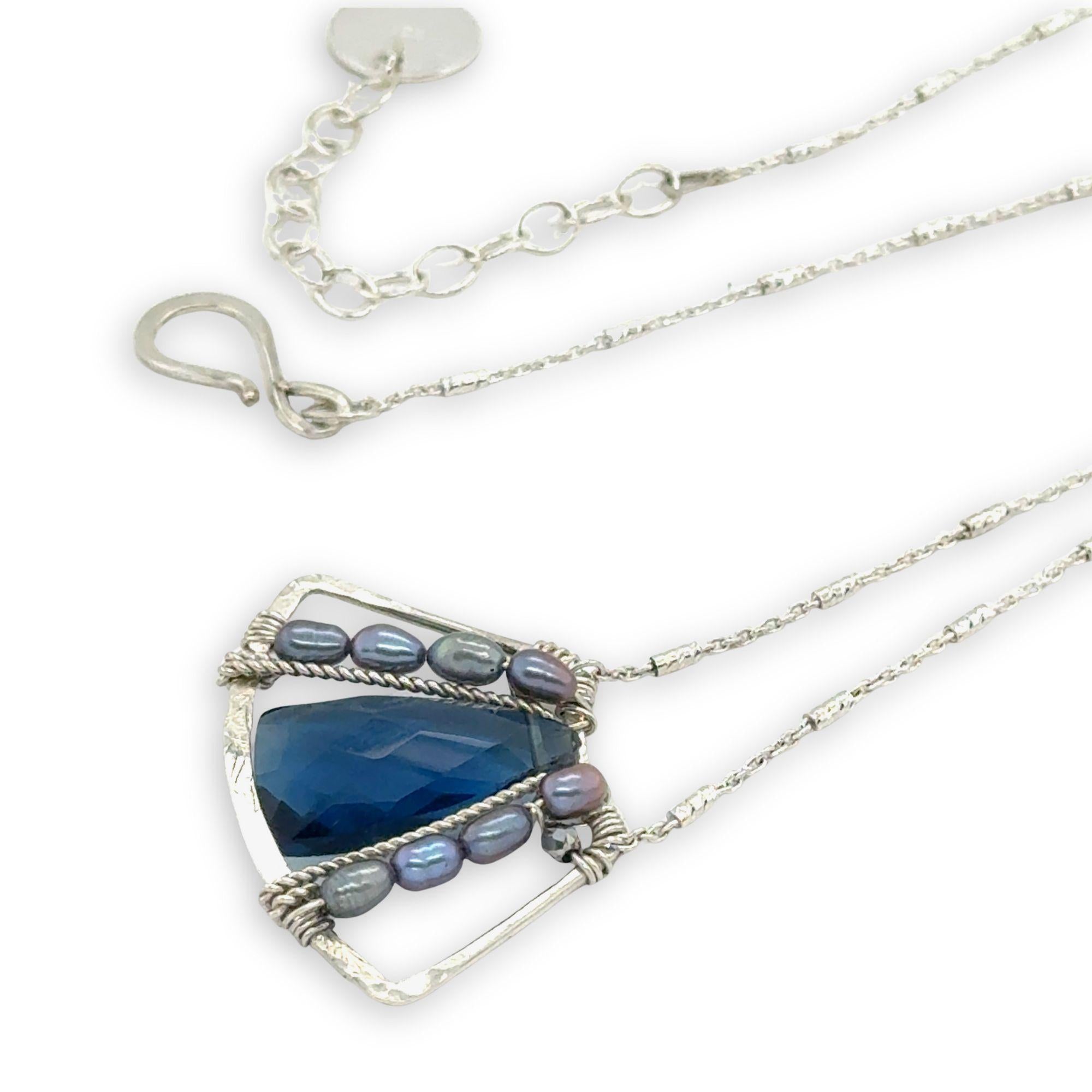 London blue quartz pointed gemstone sits at the center of mini sterling silver pendant with light blue/purple fresh water pearls