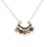 Brown striped agate coins line the inside of a sterling silver and brass fan shaped pendant necklace with pyrite and gold fill accents